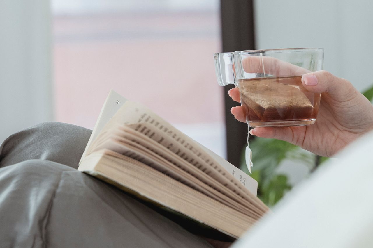 Tasse de tisane du soir avec livre, ambiance cosy